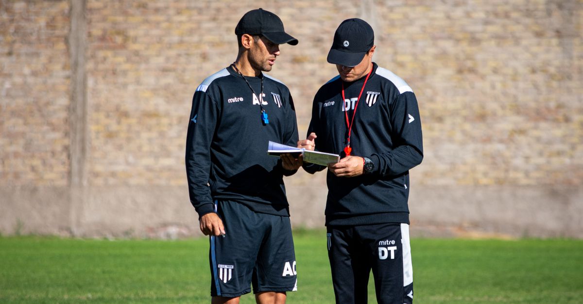 Two soccer coaches reviewing strategies on the field.