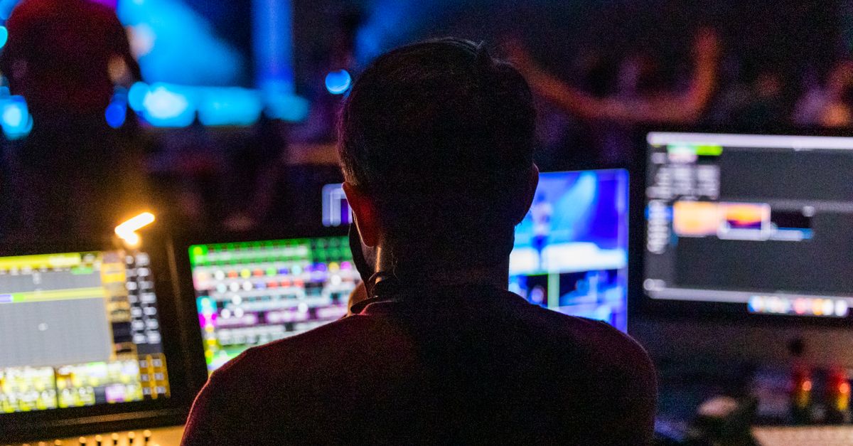 Event producer at a live control panel with multiple screens.